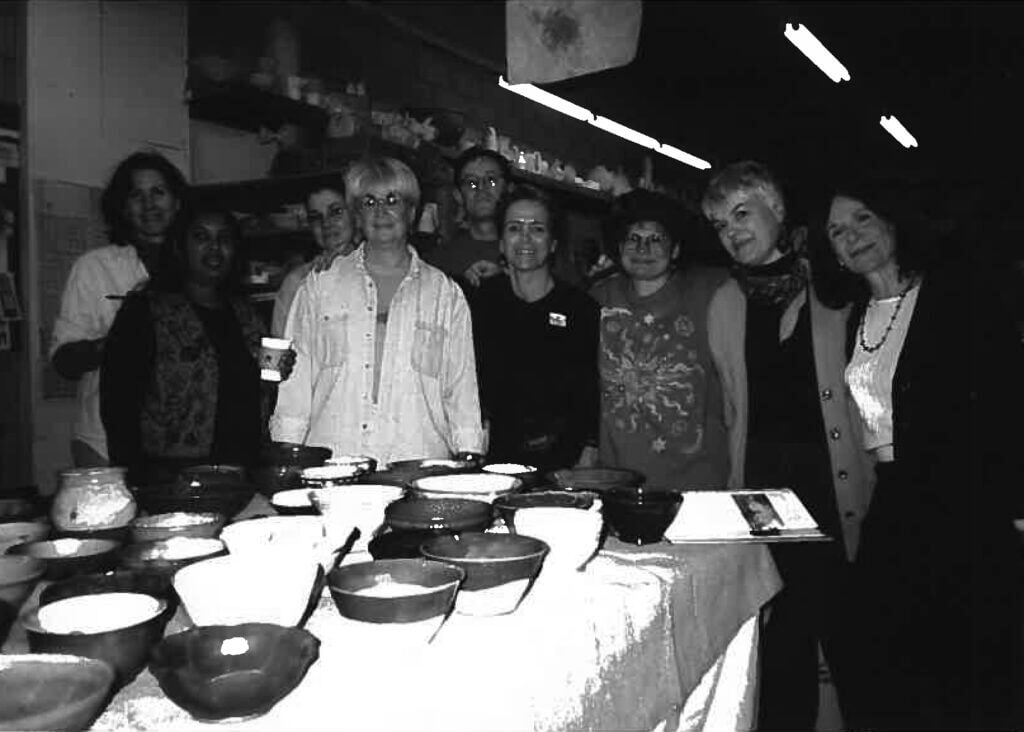 Black and White photo of a group of women behind a table of bowls